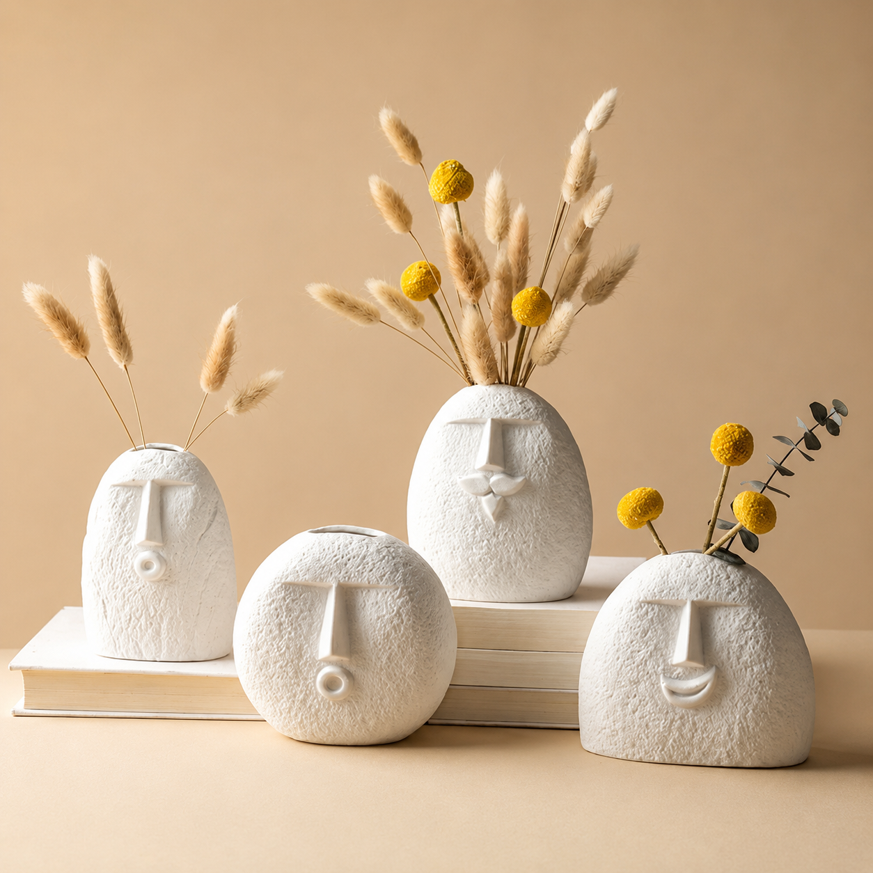 Abstract face ceramic vases with dried flowers on a beige background
