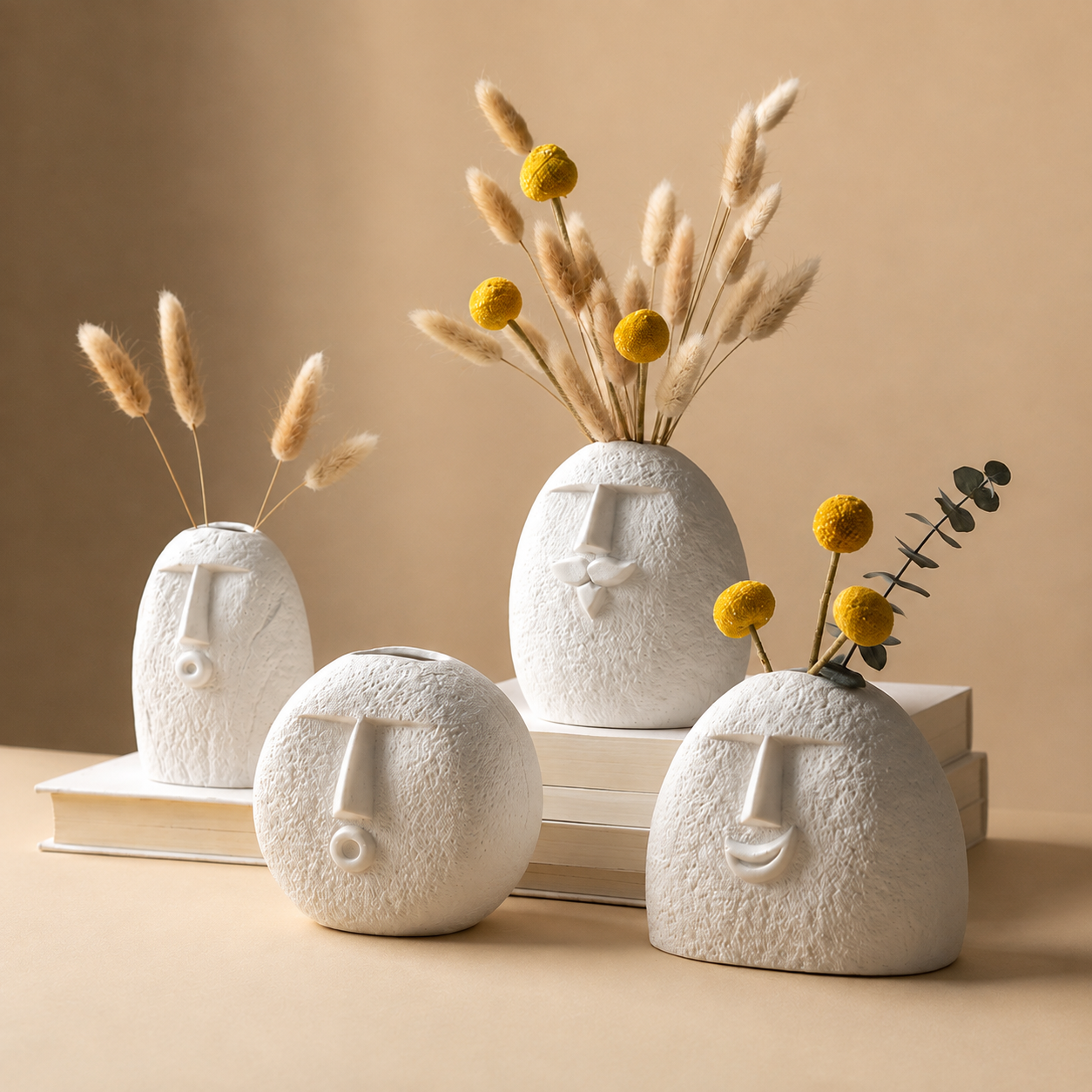 Set of four abstract face ceramic vases styled with pampas grass and craspedia
