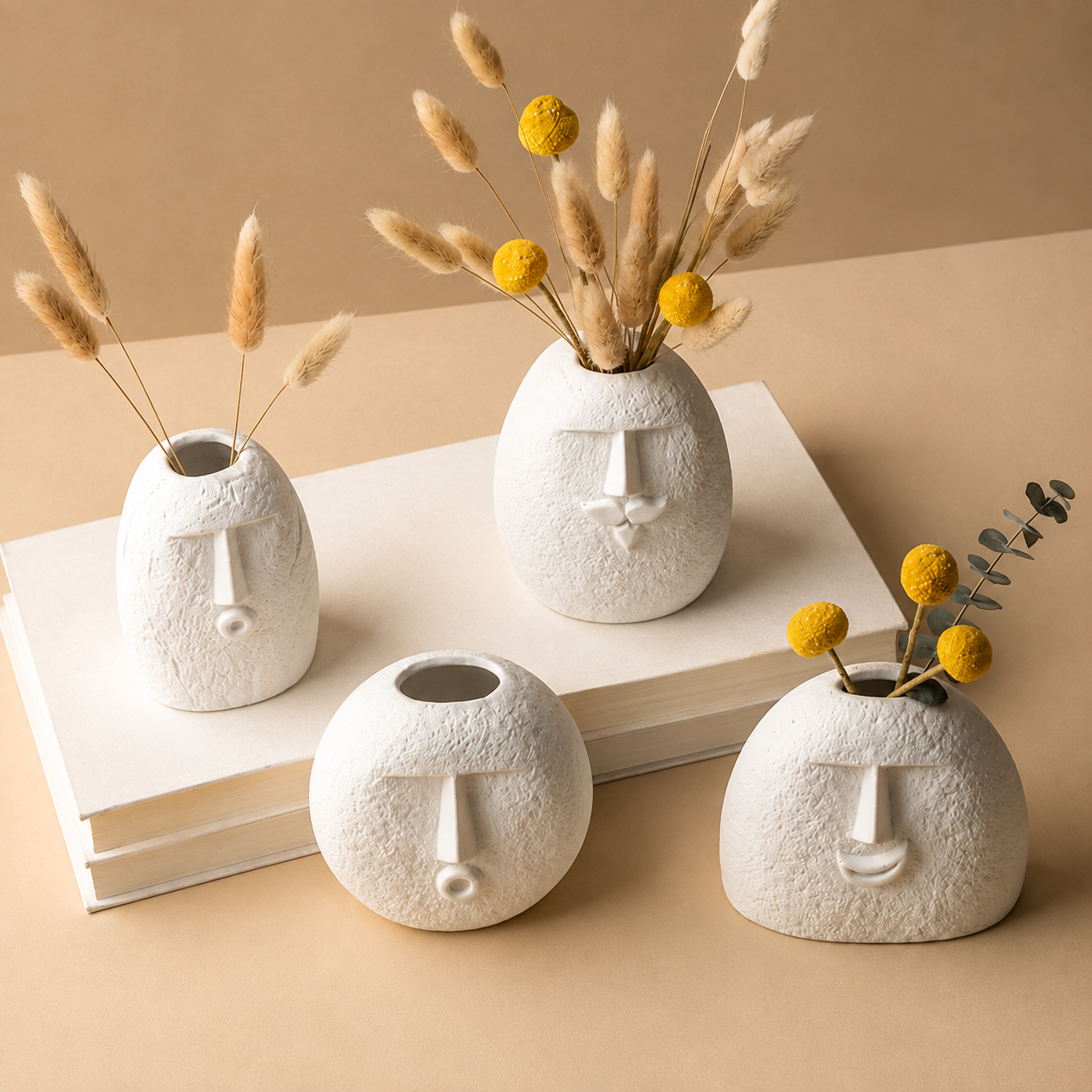 Abstract face ceramic vases in different shapes displayed on stacked books