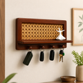 Rattan wood key holder with shelf mounted on a cream wall with keys hanging from hooks