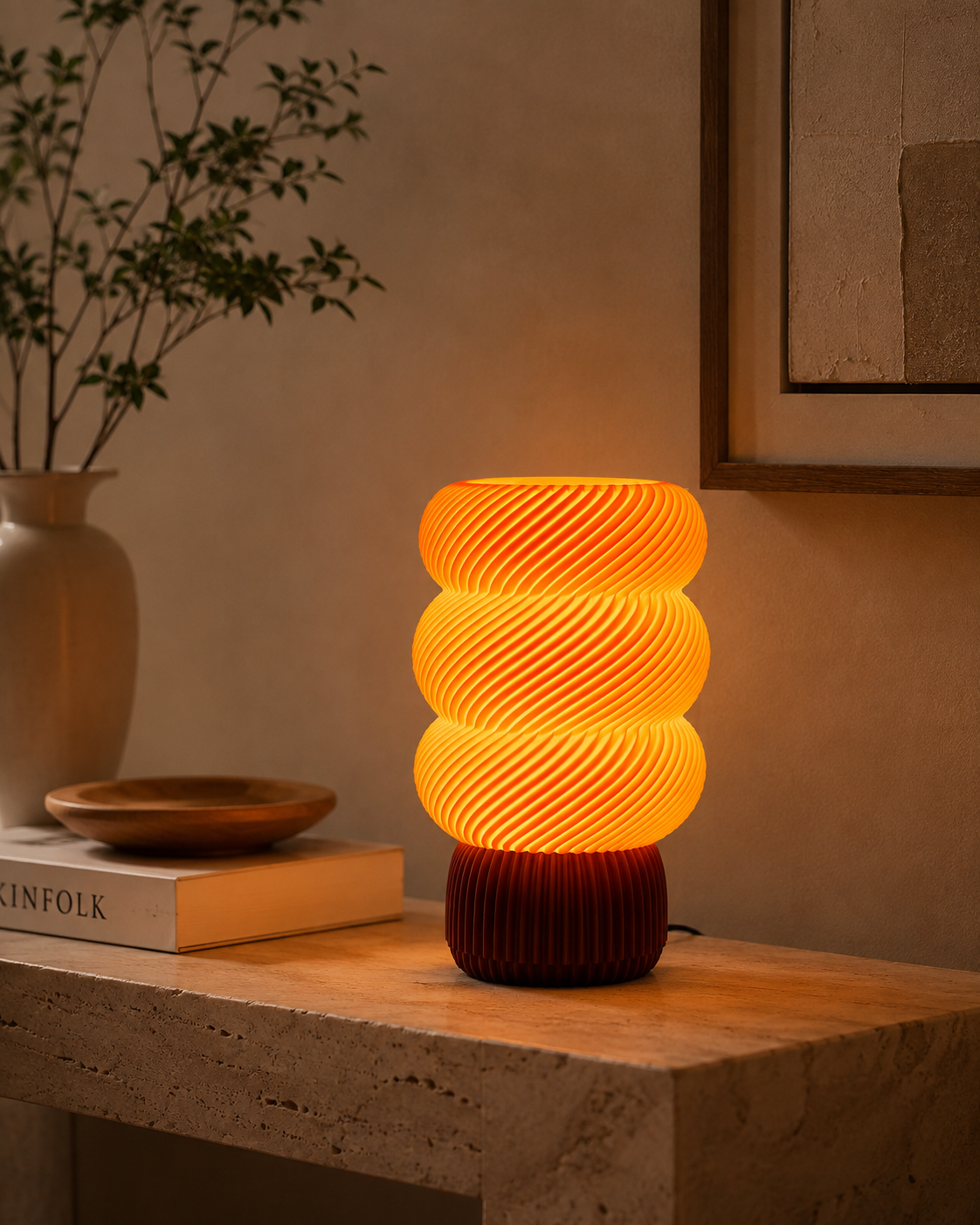 Sculptural spiral wave lamp on a travertine console with ceramic vase and books in a warm living room