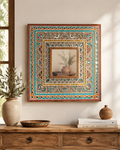 Hand-painted Rajasthani folk art square mirror with multicolour peacock and paisley frame above a wooden console with ceramic vase and bowl
